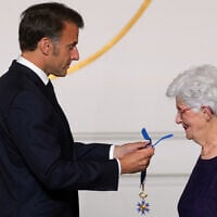 Le président français Emmanuel Macron remet à Lili Keller-Rosenberg (Lili Leignel), survivante de la Shoah, les insignes de commandeur dans l'Ordre du mérite, lors du Concours national de la Résistance et de la Déportation, au palais de l'Élysée à Paris, le 7 mai 2025. Le Concours national de la Résistance et de la Déportation, créé en 1961 par le ministère de l'Éducation nationale, est fondé sur l'enseignement de l'histoire, de l'histoire des mémoires, de la Résistance et de la Déportation, élément essentiel de l'éducation civique de l'élève. (Crédit : Michel Euler / POOL / AFP)