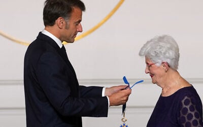 Le président français Emmanuel Macron remet à Lili Keller-Rosenberg (Lili Leignel), survivante de la Shoah, les insignes de commandeur dans l'Ordre du mérite, lors du Concours national de la Résistance et de la Déportation, au palais de l'Élysée à Paris, le 7 mai 2025. Le Concours national de la Résistance et de la Déportation, créé en 1961 par le ministère de l'Éducation nationale, est fondé sur l'enseignement de l'histoire, de l'histoire des mémoires, de la Résistance et de la Déportation, élément essentiel de l'éducation civique de l'élève. (Crédit : Michel Euler / POOL / AFP)