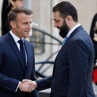 Le président français Emmanuel Macron (à gauche) salue le président intérimaire syrien Ahmed al-Sharaa à son arrivée pour leur rencontre au palais présidentiel de l'Élysée à Paris, le 7 mai 2025. (Crédit : Ludovic MARIN / AFP)