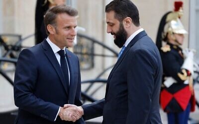 Le président français Emmanuel Macron (à gauche) salue le président intérimaire syrien Ahmed al-Sharaa à son arrivée pour leur rencontre au palais présidentiel de l'Élysée à Paris, le 7 mai 2025. (Crédit : Ludovic MARIN / AFP)