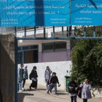 Des écolières palestiniennes quittent une école de l'UNRWA dans le camp de réfugiés de Shoafat à Jérusalem-Est, le 8 mai 2025, alors que les forces de sécurité israéliennes s'apprêtent à fermer l'école (Crédit : Ahmad GHARABLI / AFP)