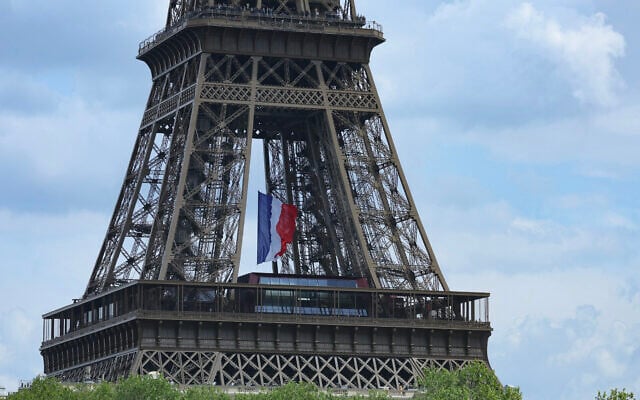Un drapeau français géant est suspendu à la Tour Eiffel dans le cadre des cérémonies de commémoration du 80e anniversaire de la victoire en Europe du 8 mai 1945 et de la fin de la Seconde Guerre mondiale en Europe, à Paris, le 8 mai 2025. (Crédit : Thomas SAMSON / AFP) Un drapeau français géant est suspendu à la Tour Eiffel dans le cadre des cérémonies de commémoration du 80e anniversaire de la victoire en Europe du 8 mai 1945 et de la fin de la Seconde Guerre mondiale en Europe, à Paris, le 8 mai 2025. (Crédit : Thomas SAMSON / AFP)
