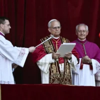 Le pape nouvellement élu Léon XIV, Robert Prevost, s'adresse à la foule depuis le balcon de la basilique Saint-Pierre pour la première fois, au Vatican, le 8 mai 2025. (Crédit : Filippo MONTEFORTE / AFP)