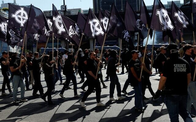 Des membres du groupe d'extrême droite « Comité du 9 Mai » (C9M) participent à une manifestation pour commémorer le 30e anniversaire de la mort de Sébastien Deyzieu du groupe ultranationaliste « Oeuvre française », lors d'un rassemblement à Port-Royal à Paris, le 10 mai 2025. Sébastien Deyzieu est mort après avoir fait une chute alors qu'il était poursuivi par la police à la suite d'une manifestation d'extrême droite à Paris en 1994. (Crédit : GEOFFROY VAN DER HASSELT / AFP)