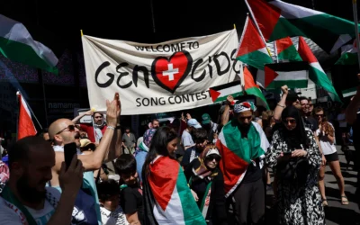 Des manifestants tiennent une bannière et des drapeaux palestiniens lors d'une manifestation contre la candidate d'Israël pendant la cérémonie d'ouverture du Concours Eurovision de la chanson 2025 à Bâle, le 11 mai 2025. (Crédit Stefan Wermuth / AFP)