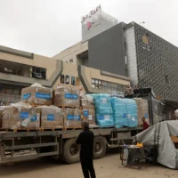 Un Palestinien se tenant à côté d'un camion transportant des fournitures d'aide de l'UNICEF, à l'extérieur d'un centre commercial à Gaza-City, le 12 mai 2025. (Crédit : Omar al-Qattaa/AFP)