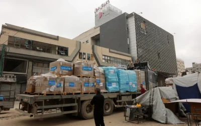 Un Palestinien se tenant à côté d'un camion transportant des fournitures d'aide de l'UNICEF, à l'extérieur d'un centre commercial à Gaza-City, le 12 mai 2025. (Crédit : Omar al-Qattaa/AFP)