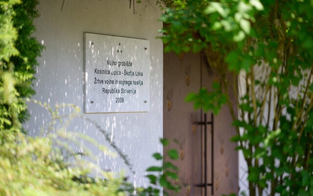 Une plaque à l'entrée de l'ossuaire de Lipica, dans le cimetière de Lipica, à Skofja Loka, en Slovénie, le 30 avril 2025. (Crédit : Jure Makovec/AFP)