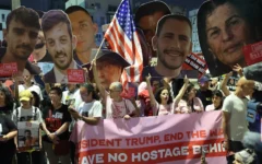 Des parents et des sympathisants d'Israéliens retenus en otage à Gaza par les terroristes palestiniens brandissent des pancartes et des drapeaux israéliens en demandant aux Etats-Unis d'intervenir pour leur libération, devant le bureau de l'ambassade des Etats-Unis à Tel Aviv, le 13 mai 2025. (Crédit : Jack Guez/AFP)