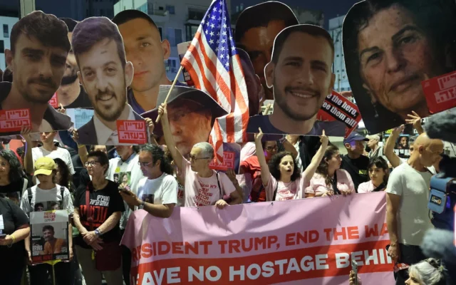 Des parents et des sympathisants d'Israéliens retenus en otage à Gaza par les terroristes palestiniens brandissent des pancartes et des drapeaux israéliens en demandant aux Etats-Unis d'intervenir pour leur libération, devant le bureau de l'ambassade des Etats-Unis à Tel Aviv, le 13 mai 2025. (Crédit : Jack Guez/AFP)