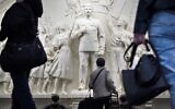 Des usagers de métro font une pause en passant devant le bas-relief récemment dévoilé représentant le dictateur soviétique Joseph Staline dans un passage de la station de métro Taganskaïa à Moscou, le 15 mai 2025. Le 15 mai 2025, les autorités moscovites ont dévoilé un bas-relief représentant Joseph Staline dans le métro de la capitale russe, alors que le Kremlin s'efforce depuis des années de réhabiliter le dictateur, en promouvant une version ultra-patriotique de l'histoire qui passe sous silence la répression de l'ère soviétique. Le métro de Moscou a dévoilé la réplique du bas-relief du dictateur soviétique à l'intérieur de la station centrale Taganskaïa, qui avait été détruite dans les années 1960 lors de la campagne de déstalinisation. (Crédit : Alexander NEMENOV / AFP)