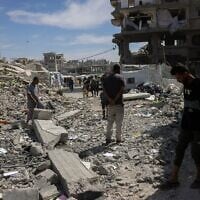 Des habitants inspectent les décombres d’un bâtiment touché par une frappe israélienne à Jabaliya, dans le nord de la bande de Gaza, le 15 mai 2025. (Crédit : Bashar Taleb / AFP)