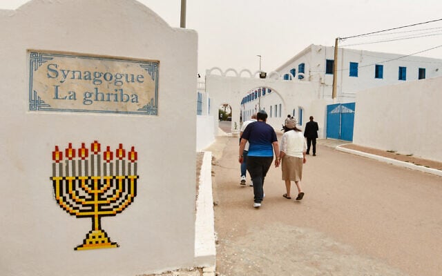 Des pèlerins juifs se dirigent vers la synagogue historique de la Ghriba sur l'île tunisienne de Djerba, lors du pèlerinage juif annuel, le 15 mai 2025. (Crédit : FETHI BELAID / AFP)