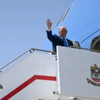 Le président américain Donald Trump fait un signe d'adieu alors qu'il se prépare à monter à bord d'Air Force One à Abou Dhabi, aux Émirats arabes unis, le 16 mai 2025. (Crédit : Brendan SMIALOWSKI / AFP)