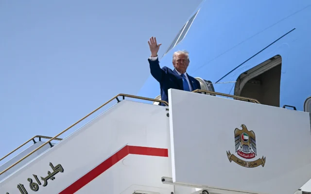 Le président américain Donald Trump fait un signe d'adieu alors qu'il se prépare à monter à bord d'Air Force One à Abou Dhabi, aux Émirats arabes unis, le 16 mai 2025. (Crédit : Brendan SMIALOWSKI / AFP)