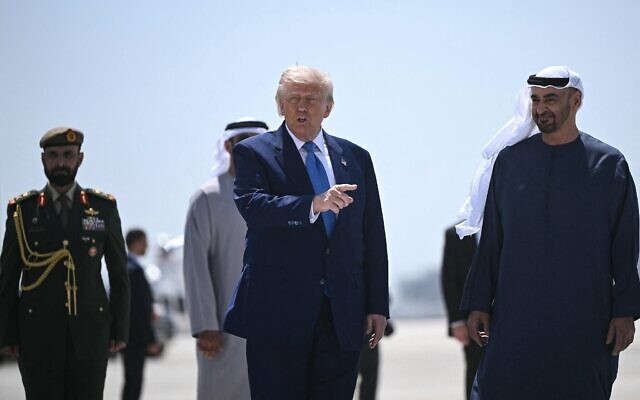 Le président américain Donald Trump (au centre) s'apprêtant à monter à bord de l'Air Force One, à Abou Dhabi à la fin de sa tournée au Moyen-Orient, le 16 mai 2025. (Crédit : Brendan Smialowski/AFP)