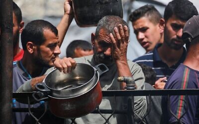 Des Palestiniens réagissent à l'épuisement des réserves en nourriture d'une cuisine communautaire fournissant des repas chauds à Jabaliya, dans le nord de la bande de Gaza, le 17 mai 2025. (Crédit : Bashar Taleb / AFP)