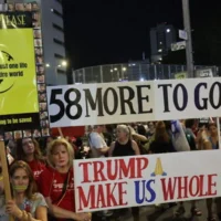 Des manifestants brandissant des pancartes lors d'un rassemblement anti-gouvernement, à Tel Aviv, le 17 mai 2025. (Crédit : Jack Guez/AFP)