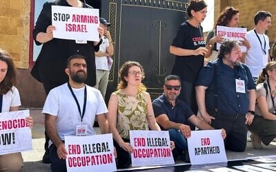 Des députés italiens et européens tiennent des pancartes lors d'une manifestation du côté égyptien du point de passage de Rafah, appelant à la fin de la guerre à Gaza et à l'entrée de l'aide humanitaire dans l'enclave palestinienne, le 18 mai 2025. (Crédit : AFP)