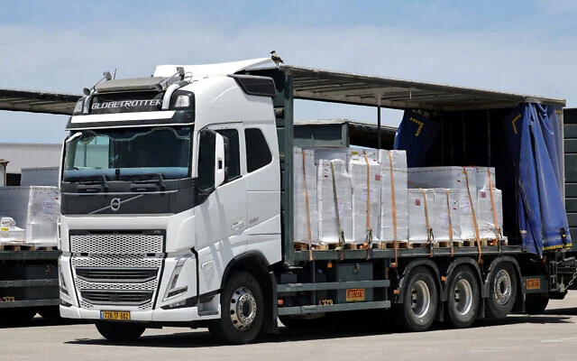 Des camions transportant de l'aide humanitaire attendent d'entrer dans la bande de Gaza au niveau du point de passage israélien de Kerem Shalom, le 20 mai 2025. (Crédit : Jack Guez/AFP)