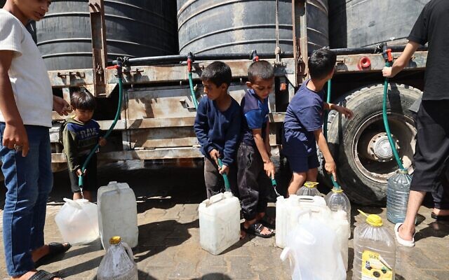 Des enfants gazaouis remplissant des récipients d'eau dans le camp de réfugiés de Nuseirat, dans le centre de la bande de Gaza, le 24 mai 2025. (Crédit : Eyad Baba/AFP) Des enfants gazaouis remplissant des récipients d'eau dans le camp de réfugiés de Nuseirat, dans le centre de la bande de Gaza, le 24 mai 2025. (Crédit : Eyad Baba/AFP)
