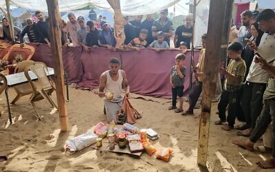 Des Palestiniens déplacés recevant des colis alimentaires dans un centre de distribution d'aide humanitaire soutenu par les États-Unis à Rafah, dans le sud de la bande de Gaza, le 27 mai 2025. (Crédit : AFP)