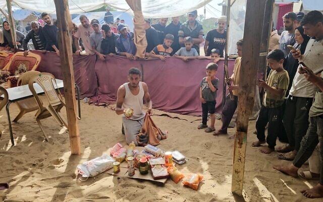 Des Palestiniens déplacés recevant des colis alimentaires dans un centre de distribution d'aide humanitaire soutenu par les États-Unis à Rafah, dans le sud de la bande de Gaza, le 27 mai 2025. (Crédit : AFP) Des Palestiniens déplacés recevant des colis alimentaires dans un centre de distribution d'aide humanitaire soutenu par les États-Unis à Rafah, dans le sud de la bande de Gaza, le 27 mai 2025. (Crédit : AFP)