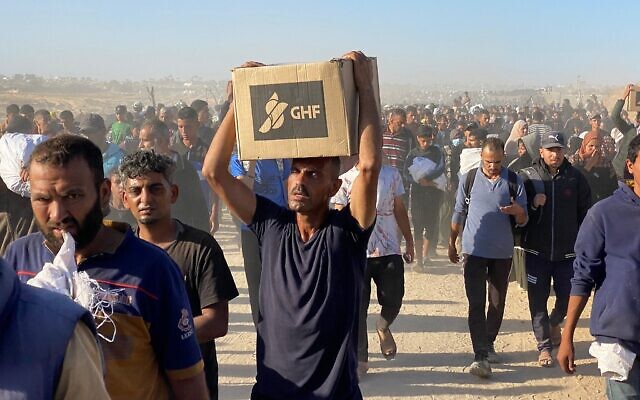 Des Palestiniens emportant des colis alimentaires de la Gaza Humanitarian Foundation, une organisation soutenue par les États-Unis qui s'est engagée à distribuer de l'aide humanitaire dans l'ouest de Rafah, dans le sud de la bande de Gaza, le 29 mai 2025. (Crédit : AFP) Des Palestiniens emportant des colis alimentaires de la Gaza Humanitarian Foundation, une organisation soutenue par les États-Unis qui s'est engagée à distribuer de l'aide humanitaire dans l'ouest de Rafah, dans le sud de la bande de Gaza, le 29 mai 2025. (Crédit : AFP)