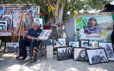 Le journaliste palestinien Ali Al Samoudi visite un sanctuaire de fortune sur le site où Shireen Abu Akleh a été tuée par balle alors qu'elle couvrait un raid israélien, dans la ville de Jénine en Cisjordanie, le 19 mai 2022. (Crédit : AP Photo/Majdi Mohammed)