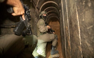 Des soldats israéliens escortent les médias dans un tunnel souterrain trouvé sous l'hôpital Al-Shifa dans la ville de Gaza, le 22 novembre 2023. (Crédit : Victor R. Caivano/AP)