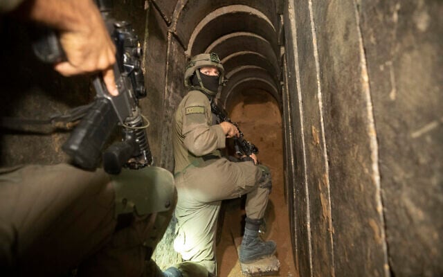 Des soldats israéliens escortent les médias dans un tunnel souterrain trouvé sous l'hôpital Al-Shifa dans la ville de Gaza, le 22 novembre 2023. (Crédit : Victor R. Caivano/AP)