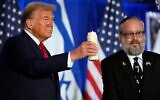 Donald Trump et le rabbin Yehuda Kaploun allumant une bougie lors d'un événement commémoratif du 7 octobre 2023, à Miami, le 7 octobre 2024. (Crédit : Alex Brandon/AP)