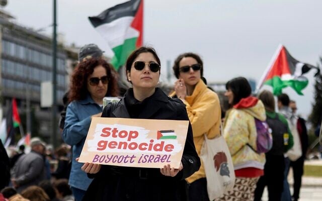 Illustration : Une manifestante anti-Israël brandissant une pancarte lors d'un rassemblement contre Israël, à Athènes, en Grèce, le 23 mars 2025. (Crédit : Yorgos Karahalis/AP)