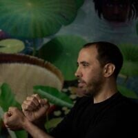 L'ex-otage israélien Tal Shoham, qui était détenu par des terroristes du Hamas dans la bande de Gaza, montre comment ses geôliers l'avaient menotté, à Tel Aviv, le 22 avril 2025. (Crédit : Maya Alleruzzo/AP)