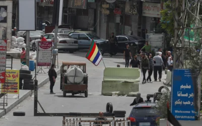 Des hommes armés druzes se tiennent à côté du drapeau religieux de leur secte à un poste de contrôle à l'une des entrées de la banlieue de Jaramana, après des affrontements dans la zone entre les membres de la secte minoritaire druze et les combattants pro-gouvernementaux, dans la banlieue sud de Jaramana, à Damas, en Syrie, le 30 avril 2025. (Crédit : Omar Sanadiki/AP)