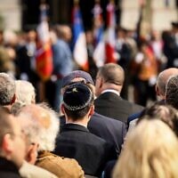 Des personnes assistant à la cérémonie marquant le 80ᵉ anniversaire du retour des déportés des camps de la mort, à Paris, en France, le 27 avril 2025. (Crédit : Thomas Padilla/AP)
