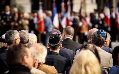 Des personnes assistant à la cérémonie marquant le 80ᵉ anniversaire du retour des déportés des camps de la mort, à Paris, en France, le 27 avril 2025. (Crédit : Thomas Padilla/AP)