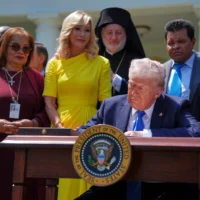 Le président Donald Trump, entouré de personnalités religieuses , signe un décret établissant la Commission de la liberté religieuse, lors de la Journée nationale de la prière dans la roseraie de la Maison-Blanche, le 1er mai 2025. (Crédit : AP/Evan Vucci)