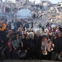 Des Palestiniens attendant la distribution de vivres dans un centre d'aide humanitaire à Beit Lahiya, dans le nord de la bande de Gaza, le 16 mars 2025. (Crédit : Abdel Kareem Hana/AP)