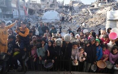 Des Palestiniens attendant la distribution de vivres dans un centre d'aide humanitaire à Beit Lahiya, dans le nord de la bande de Gaza, le 16 mars 2025. (Crédit : Abdel Kareem Hana/AP)