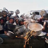 Des Palestiniens se battant pour obtenir de la nourriture distribuée dans une cuisine communautaire, à Khan Younès, dans la bande de Gaza, le 5 mai 2025. (Crédit : Abdel Kareem Hana/AP)