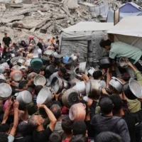 Des Palestiniens se pressent pour obtenir de la nourriture distribuée par une cuisine communautaire à Jabaliya, dans le nord de la bande de Gaza, le 15 mai 2025. (Crédit : Jehad Alshrafi/AP)