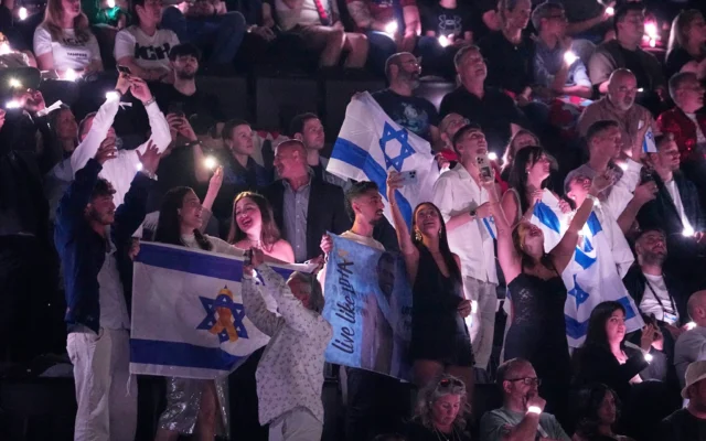 Des fans israéliens acclament Yuval Raphael alors qu'elle interprète « New Day Will Rise » lors de la deuxième demi-finale du 69e Concours Eurovision de la chanson, à Bâle, en Suisse, le 15 mai 2025. (Crédit : Martin Meissner/AP) Des fans israéliens acclament Yuval Raphael alors qu'elle interprète « New Day Will Rise » lors de la deuxième demi-finale du 69e Concours Eurovision de la chanson, à Bâle, en Suisse, le 15 mai 2025. (Crédit : Martin Meissner/AP)