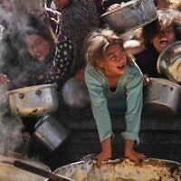 Des Palestiniens se battant pour obtenir de la nourriture distribuée dans une cuisine communautaire, à Khan Younès, dans la bande de Gaza, le 16 mai 2025. (Crédit : Abdel Kareem Hana/AP)
