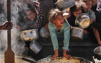 Des Palestiniens se battant pour obtenir de la nourriture distribuée dans une cuisine communautaire, à Khan Younès, dans la bande de Gaza, le 16 mai 2025. (Crédit : Abdel Kareem Hana/AP)