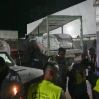 Des camions transportant des produits alimentaires arrivent à un entrepôt du Programme alimentaire mondial à Az-Zawayda, au centre de la bande de Gaza, le 21 mai 2025. (Crédit : AP Photo/Abdel Kareem Hana)