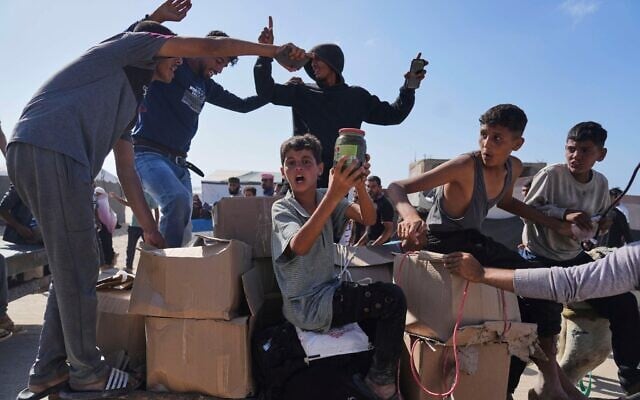 Des Palestiniens transportant des cartons contenant de la nourriture et des colis d'aide humanitaire livrés par la Gaza Humanitarian Foundation, une organisation soutenue par les États-Unis et approuvée par Israël, à Rafah, dans le sud de la bande de Gaza, le 27 mai 2025. (Crédit : Abdel Kareem Hana/AP) Des Palestiniens transportant des cartons contenant de la nourriture et des colis d'aide humanitaire livrés par la Gaza Humanitarian Foundation, une organisation soutenue par les États-Unis et approuvée par Israël, à Rafah, dans le sud de la bande de Gaza, le 27 mai 2025. (Crédit : Abdel Kareem Hana/AP)