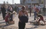 Des Palestiniens transportant des cartons contenant de la nourriture et des colis d'aide humanitaire livrés par la Gaza Humanitarian Foundation, une organisation soutenue par les États-Unis et approuvée par Israël, à Rafah, dans le sud de la bande de Gaza, le 27 mai 2025. (Crédit  : Abdel Kareem Hana/AP)