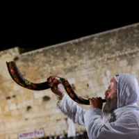 Un homme souffle dans un shofar au Mur occidental de Jérusalem, deux jours avant Yom Kippur, le 9 octobre 2024. (Crédit : Chaim Goldberg/Flash90).