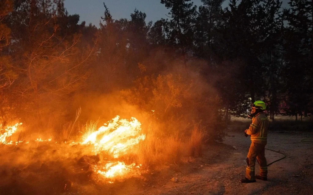 Un pompier tente d'éteindre un gigantesque incendie de forêt à Canada Park, à l'ouest de Jérusalem, le 30 avril 2025. (Crédit : Yonatan Sindel/Flash90)